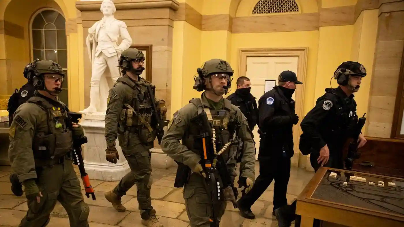 Federal officers in tactical gear securing the U.S. Capitol building during the January 6th riot.