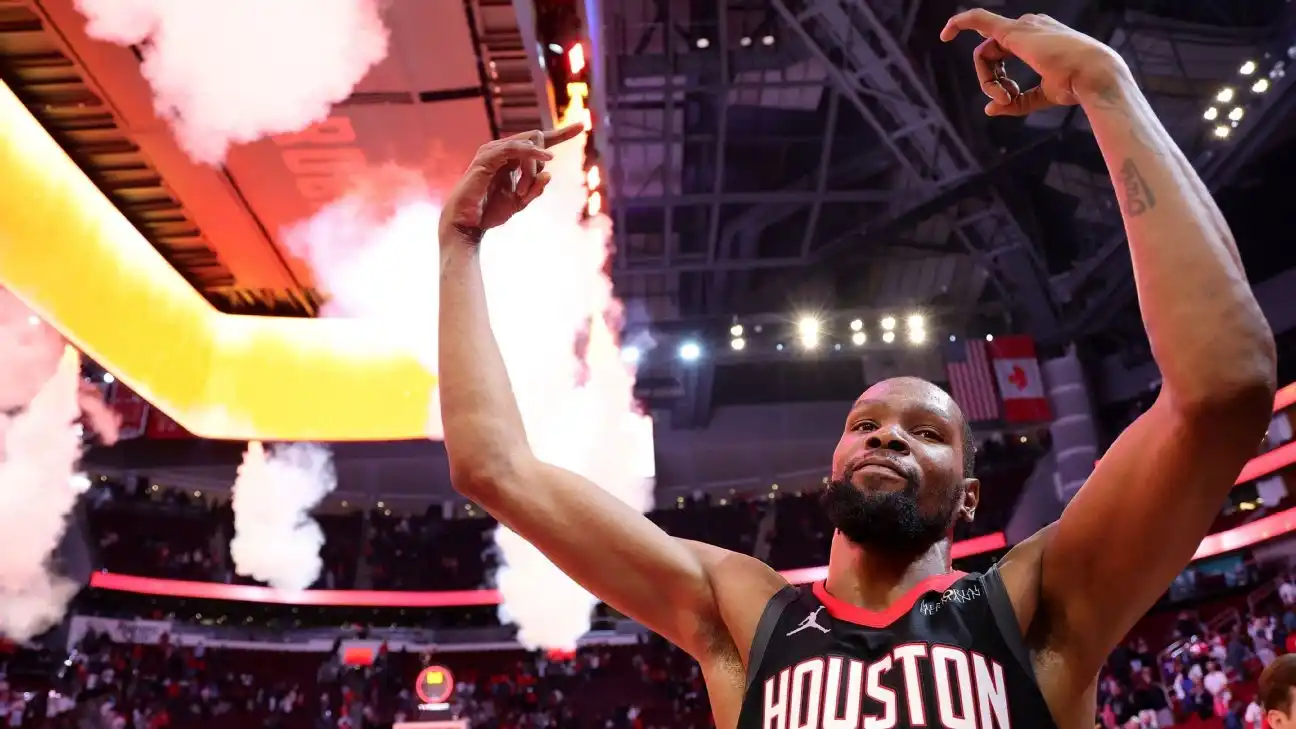 A basketball player celebrates on the court as arena lights and smoke effects fill the background.