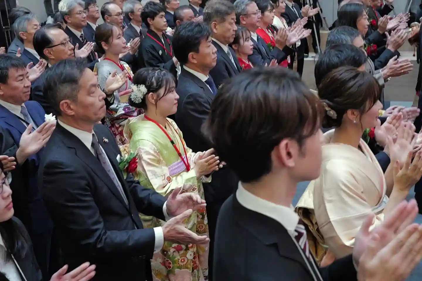 Japanese officials and guests applaud during a formal ceremony at a public event in Tokyo