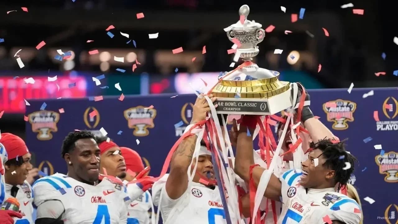 Ole Miss Rebels players lift the Sugar Bowl championship trophy amid falling confetti after defeating Georgia in the College Football Playoff quarterfinal