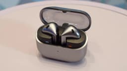 Samsung Galaxy Buds 4 and Buds 4 Pro in their charging case with blue and orange indicators.
