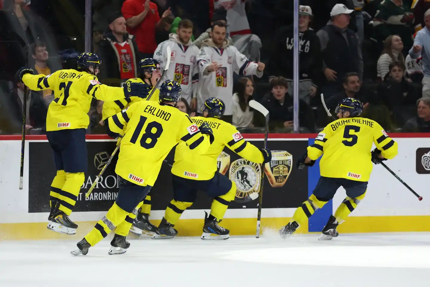 Swedish players celebrate a goal together along the boards during the World Junior Championship final.