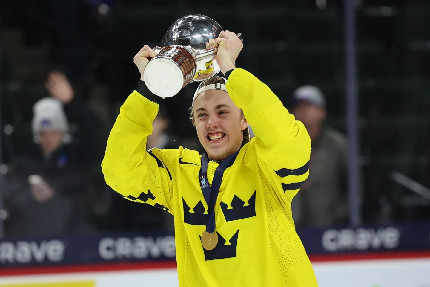 A Swedish player lifts the World Junior Championship trophy after the gold-medal win.