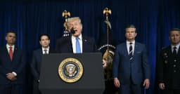 President Donald Trump delivers a speech from a podium with senior officials standing behind him