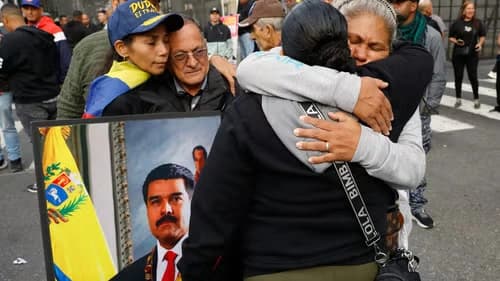Venezuelan supporters hugging in protest with a portrait of Nicolás Maduro.