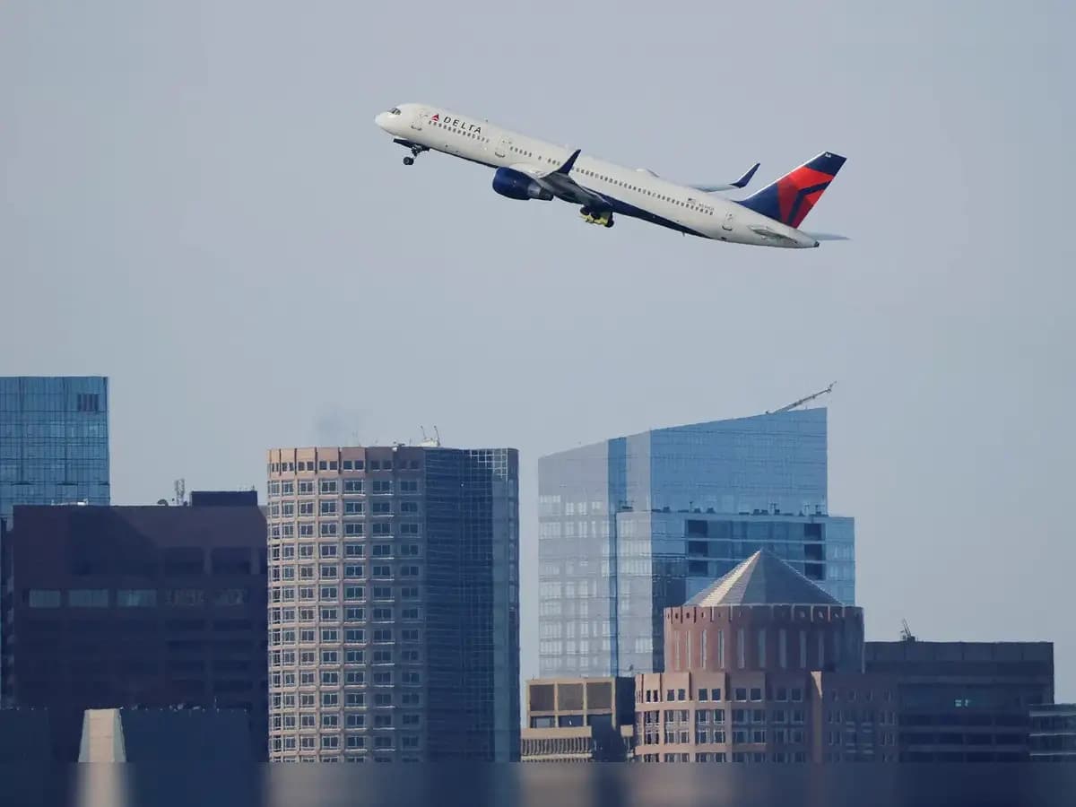 Delta Air Lines aircraft climbs after takeoff over a city skyline as flights resume in the Caribbean